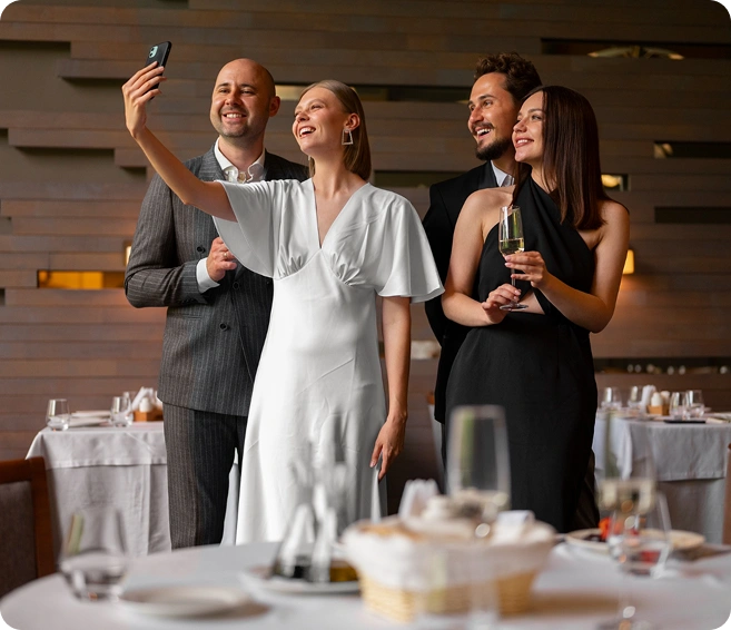Een groep vrienden geniet van een diner en maakt foto's in een restaurant; een gezellige bijeenkomst met een feestelijke sfeer.