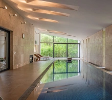 Moderne hotelspa-gang met binnenzwembad en natuurlijk licht, een luxe wellness- en ontspanningsomgeving.