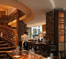 Elegant hotelrestaurantinterieur met moderne inrichting en sfeerverlichting, voor een verfijnde eetervaring.