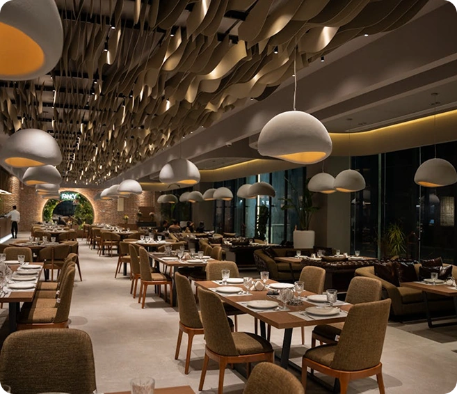 Stijlvol restaurantinterieur met moderne verlichting en keurig opgestelde tafels, een setting voor een verfijnde eetervaring.